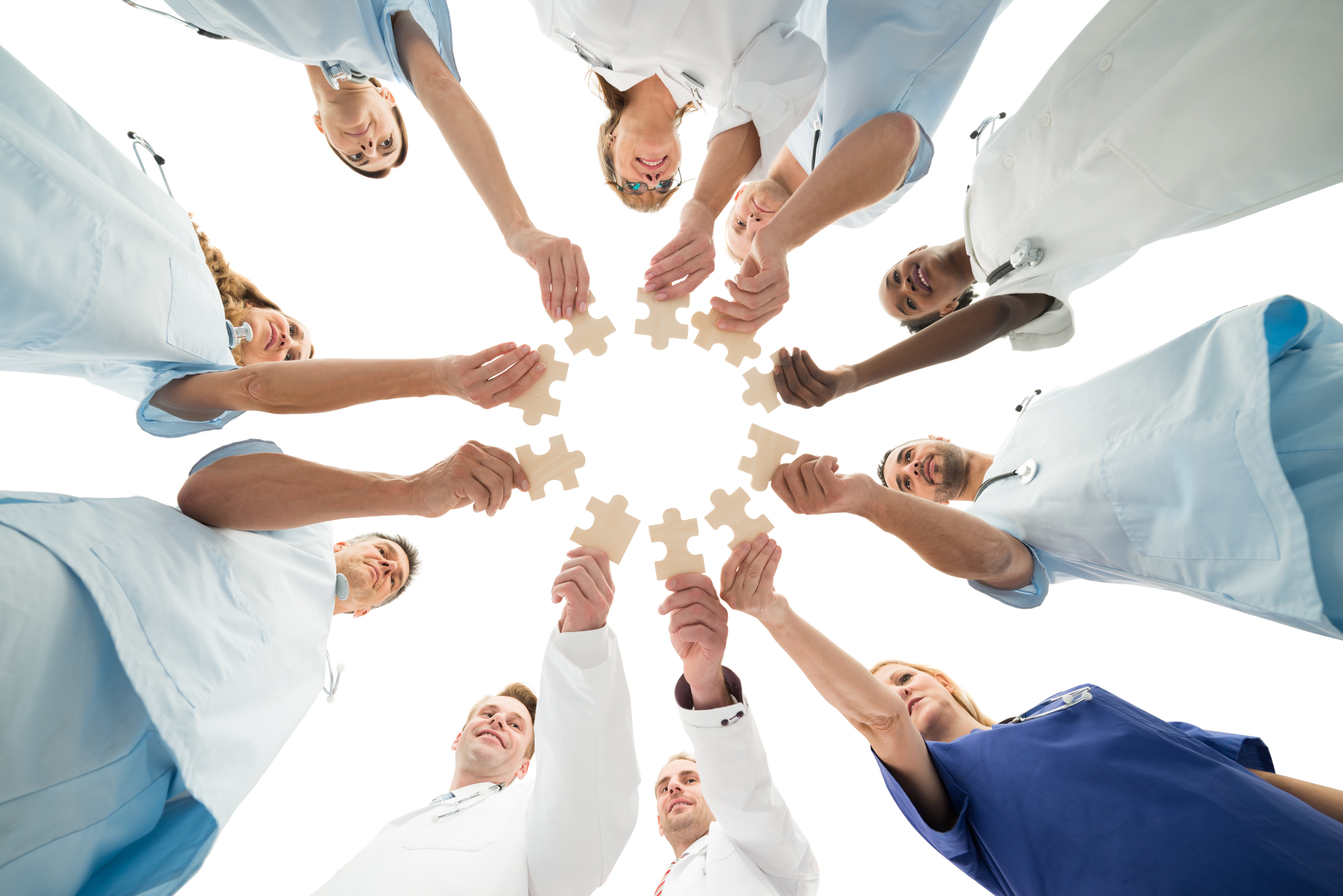 Clinicians holding puzzle pieces together to show collaboration